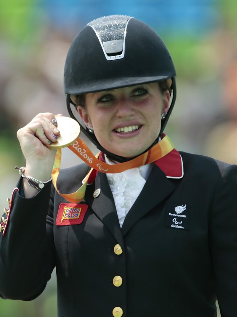 female Para equestrian rider Natasha Baker on the podium with her gold medal