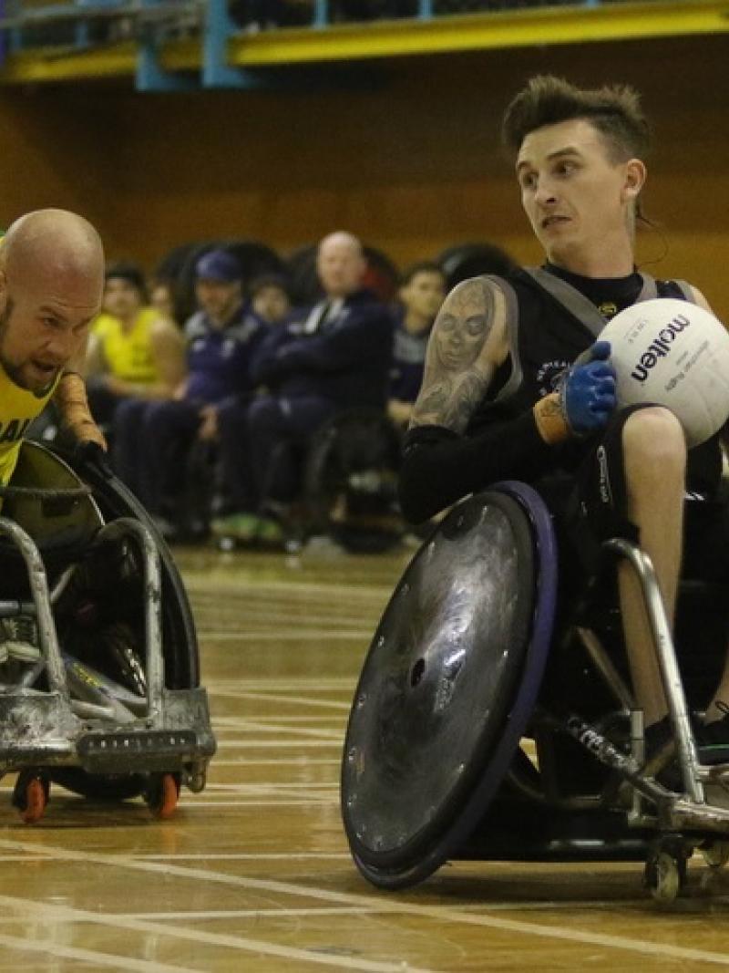 male wheelchair rugby player Cody Everson takes the ball away from another player