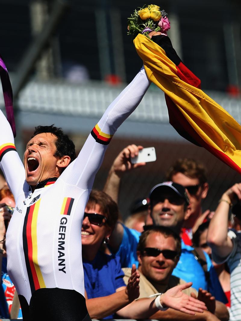 German Para cyclist Michael Teuber pumps his fist and celebrates with a German flag