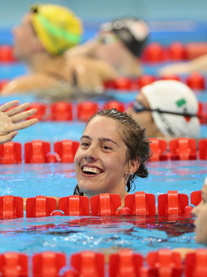 female Para swimmer Aurelie Rivard takes her swimming cap off and celebrates in the pool after winning a race
