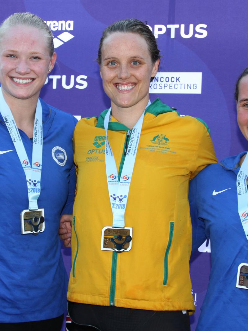 Three women with medals smiling