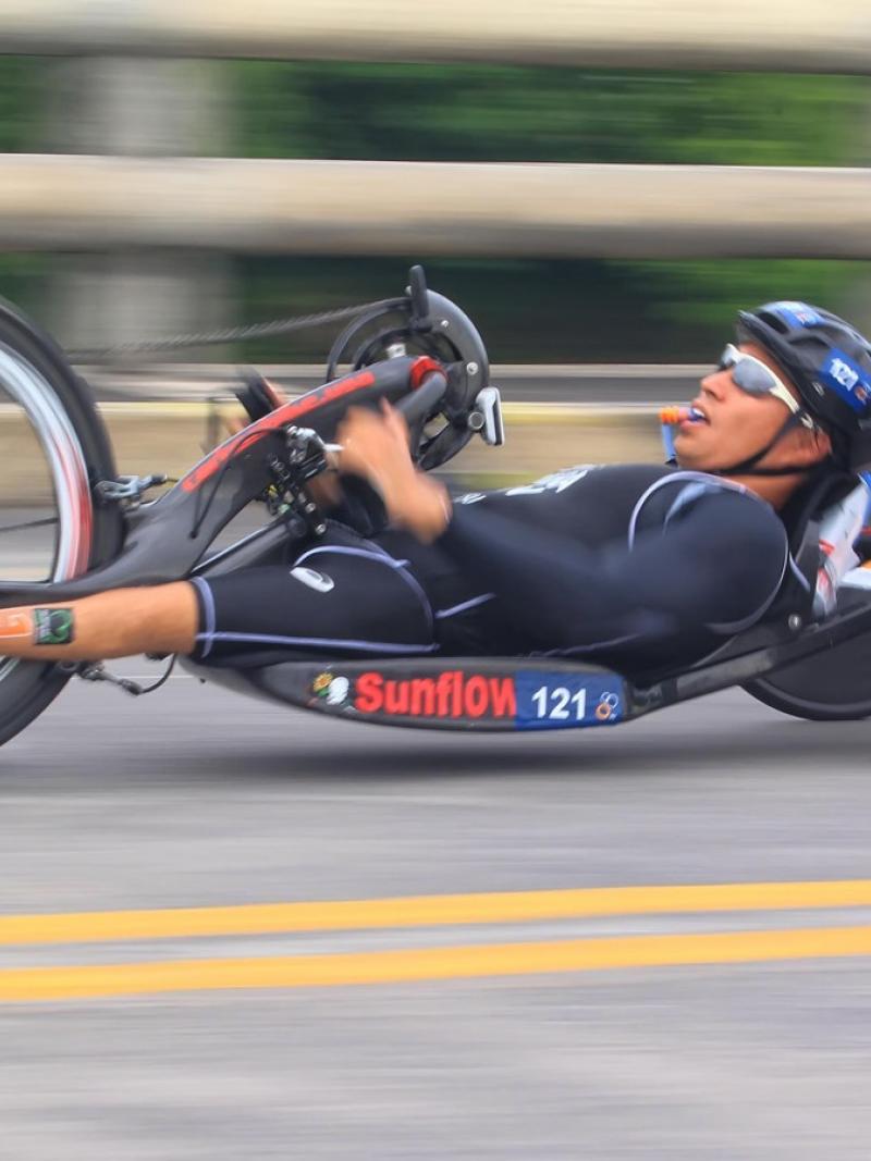 male Para triathlete Jumpei Kimura competing on a hand bike