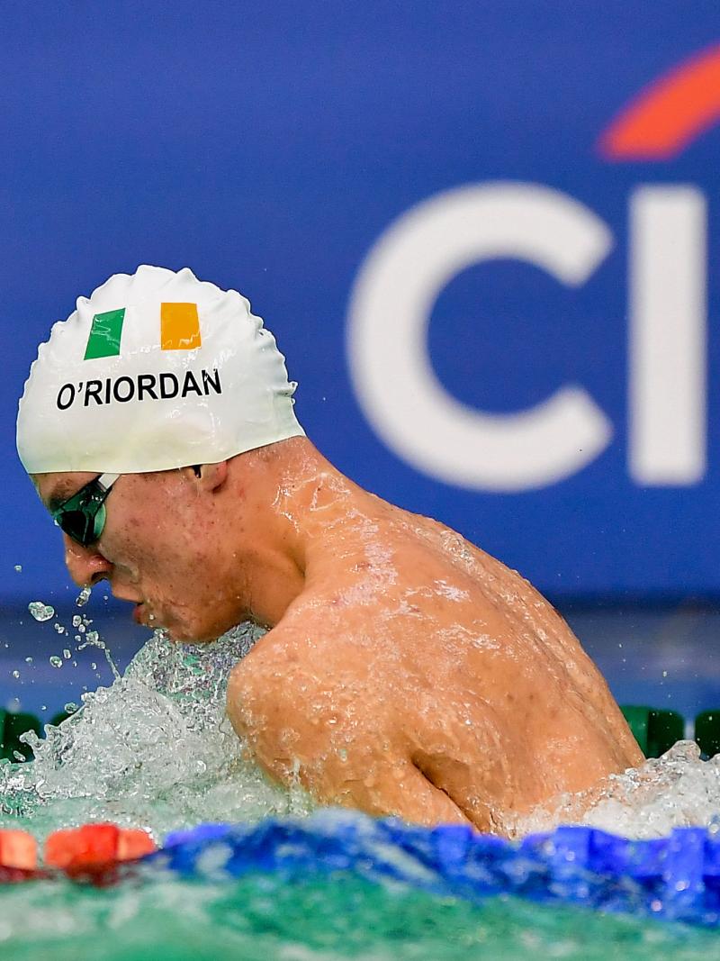 Athlete swimming with cap showing Ireland's flag