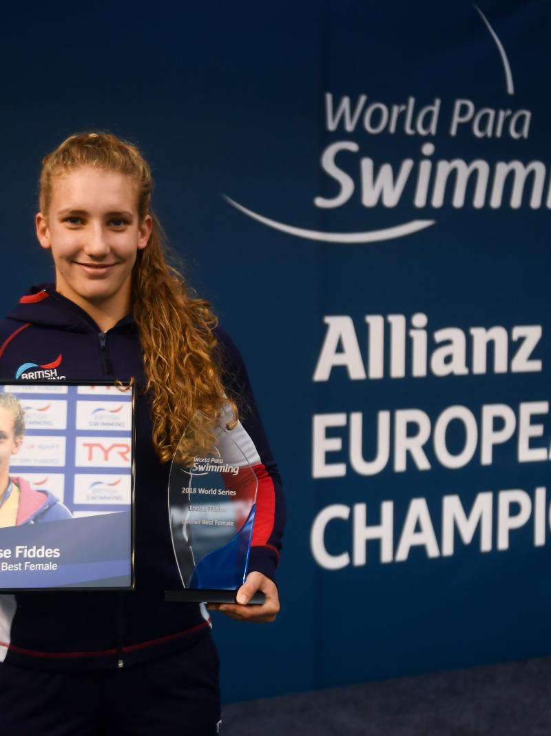 female Para swimmer Louise Fiddes smiling and holding two trophies