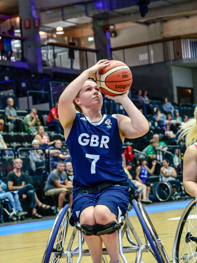 British female basketball player shoots the ball while Canadian player tries to defend