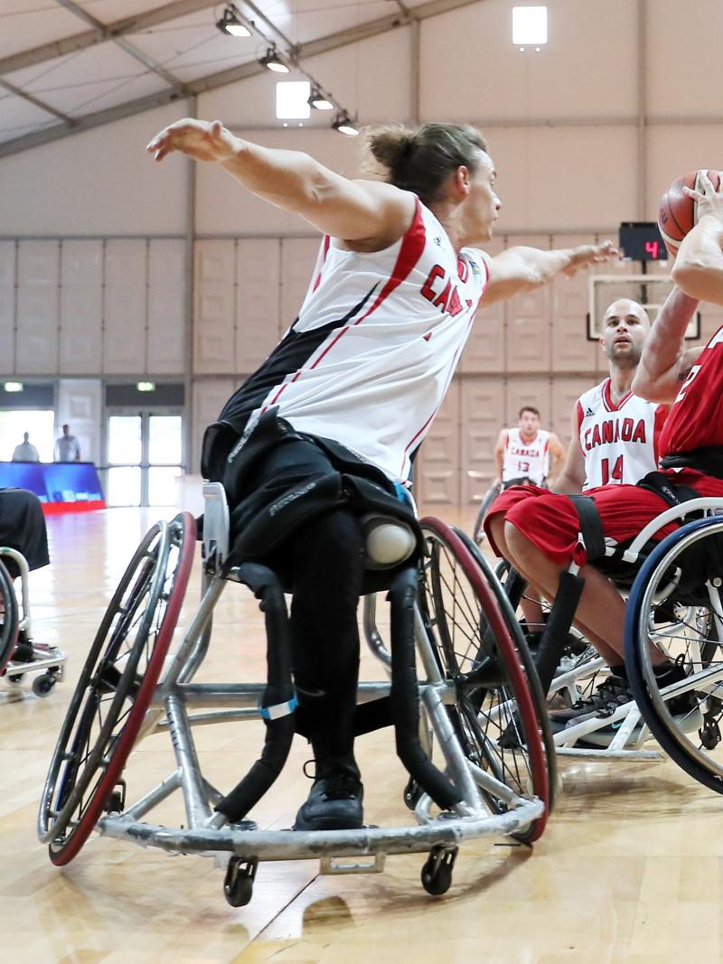 Polish and Canadian male wheelchair basketballers fighting it out on the court