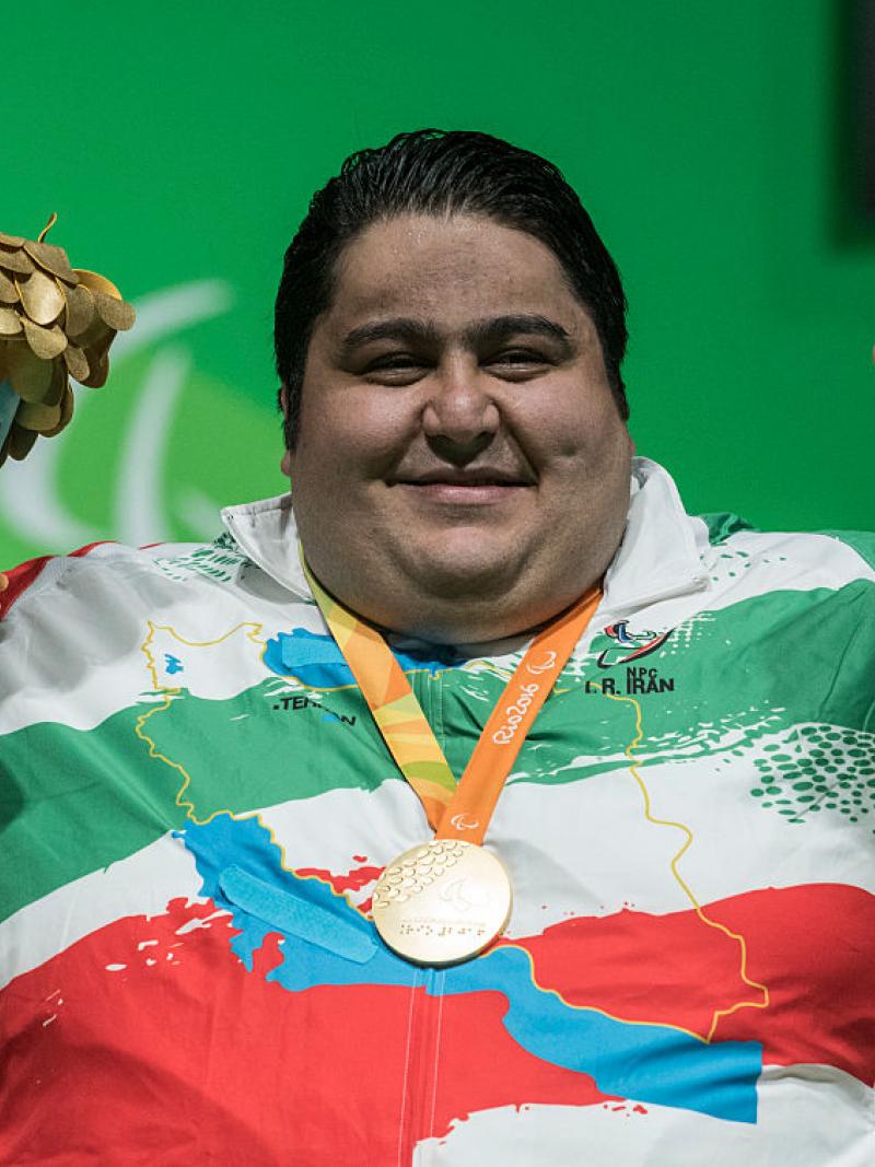 male powerlifter Siamand Rahman pumps his fist as he is wheeled onto the stage