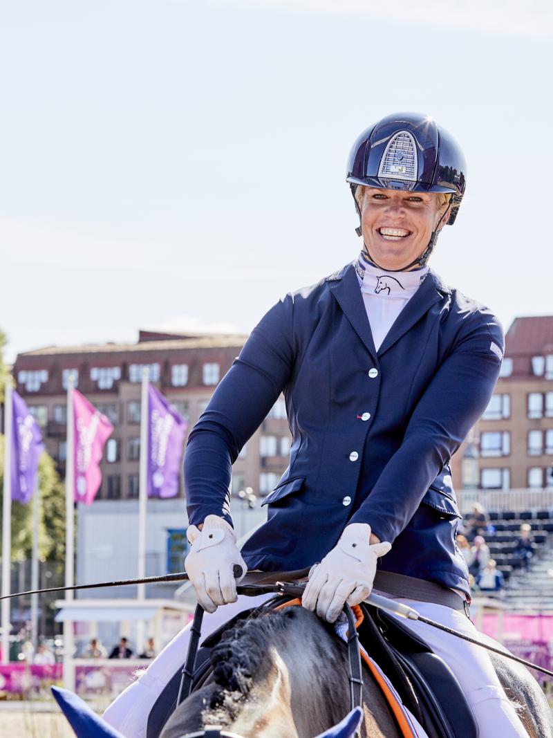 Dutch female rider smiles on her horse