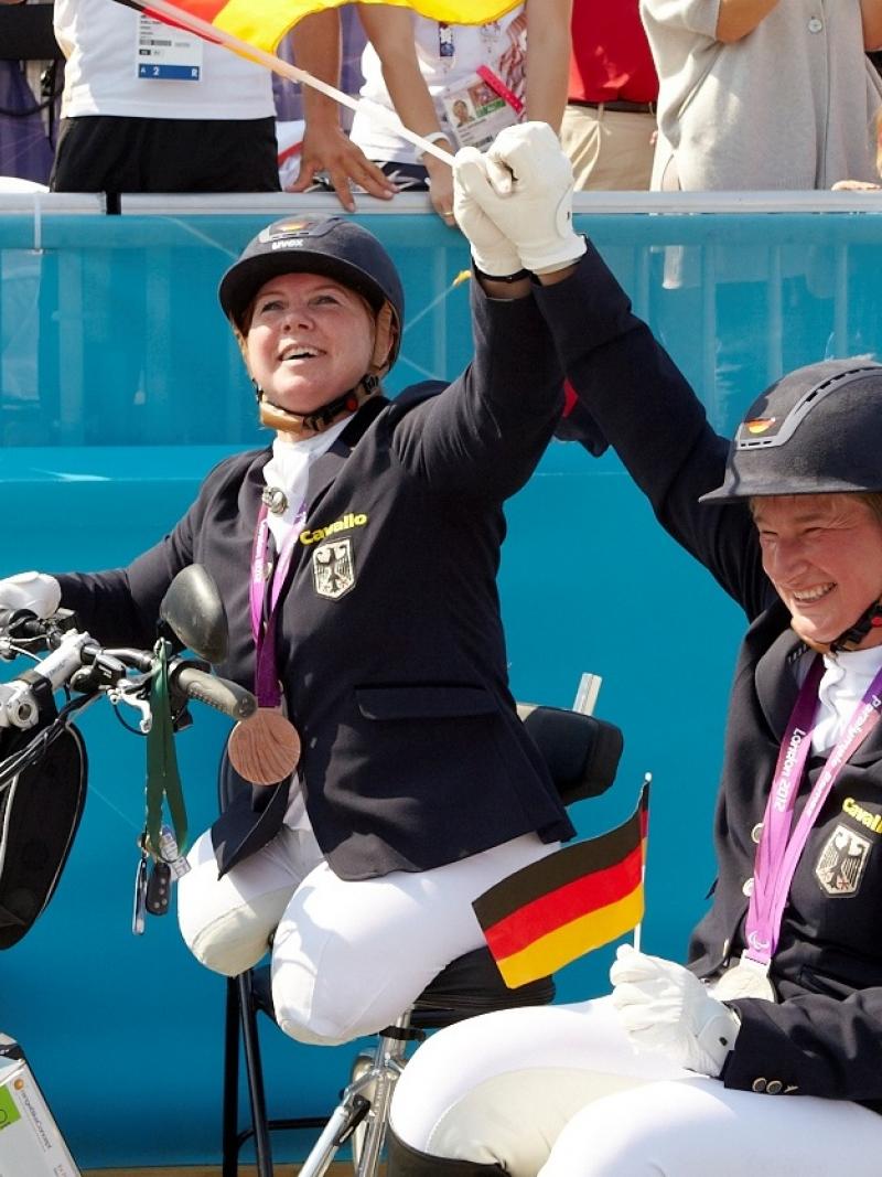 female Para equestrian rider Angelika Trabert celebrates with the German flag and her medal