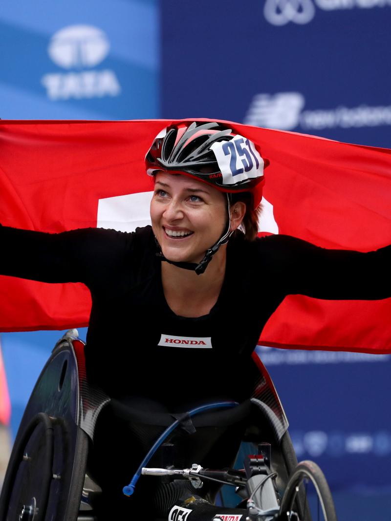 female wheelchair racer Manuela Schaer holds up the Swiss flag