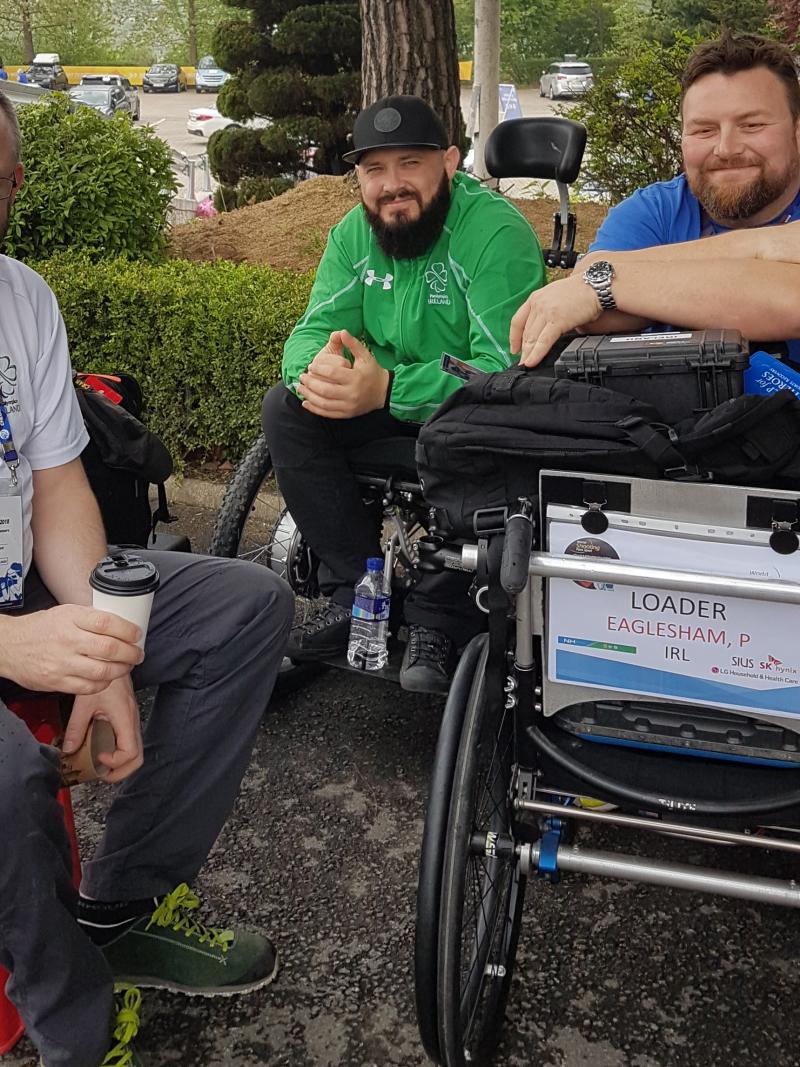 male Para shooter Phil Eaglesham with his coach and assistant outside