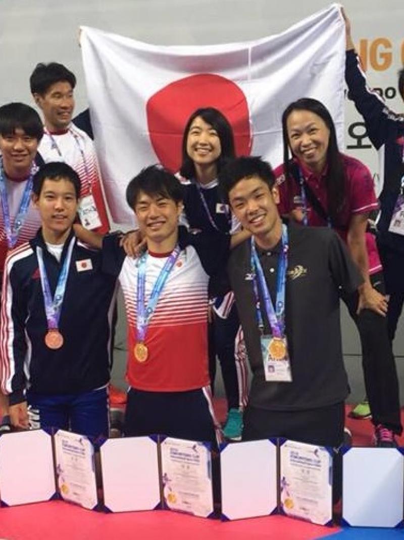 a group of Japanese Para taekwondo fighters with their medals and a Japan flag