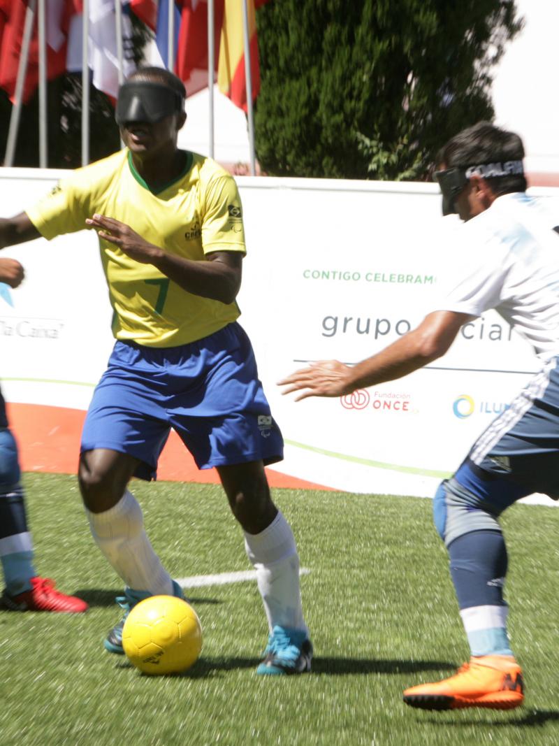 Brazilian vision impaired football dribbles the ball past Argentinian defenders