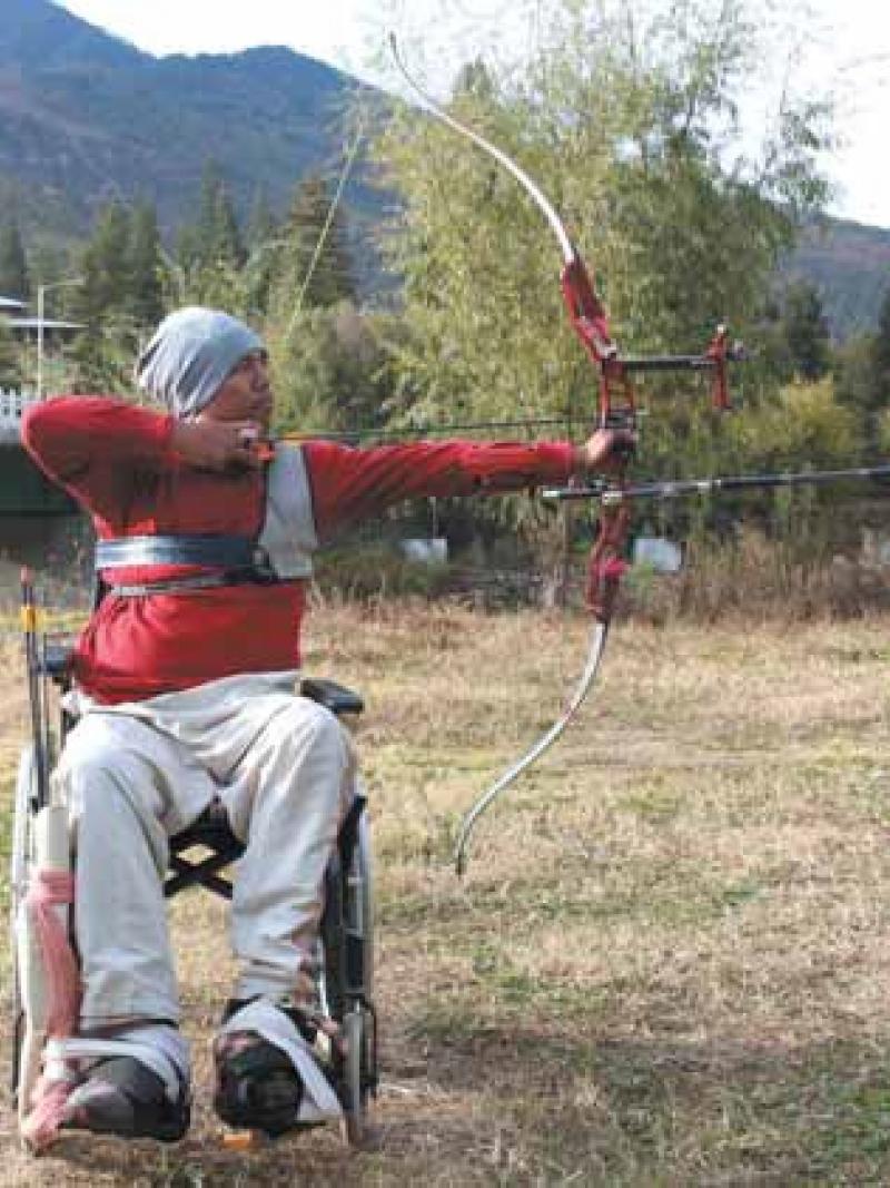 male Para archer Pema Rigsel prepares to shoot an arrow