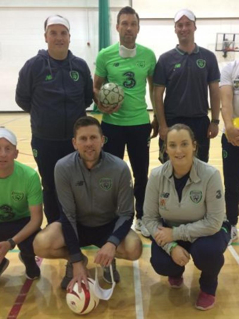 a group of blind footballers in an Ireland gym holding footballs