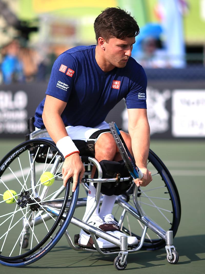 male wheelchair tennis player Gordon Reid plays a low backhand on a hard court