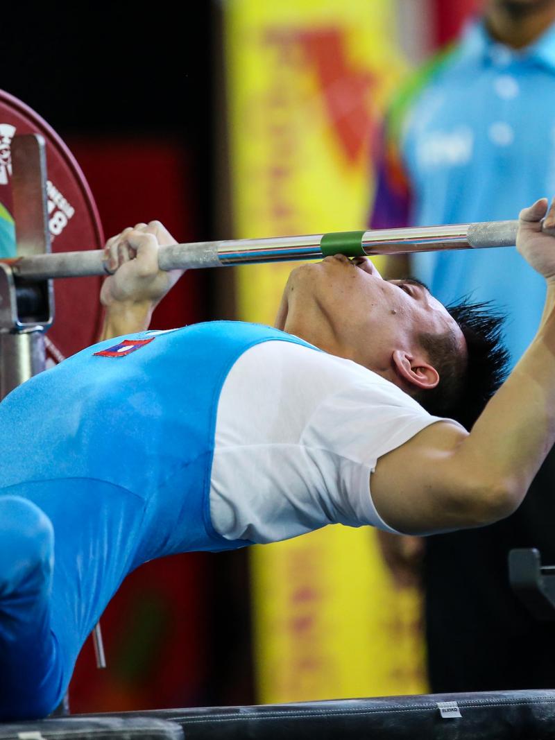 male powerlifter Pia Laophakdee kisses the bar