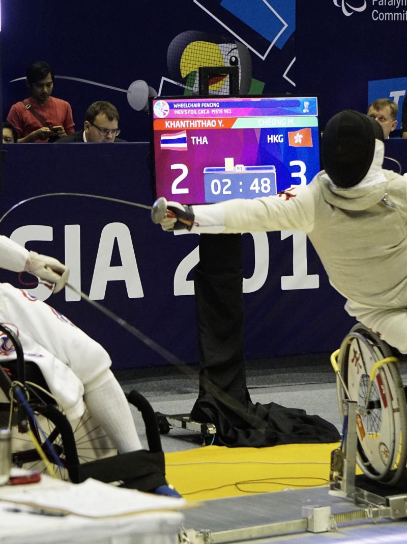 two wheelchair fencers in combat