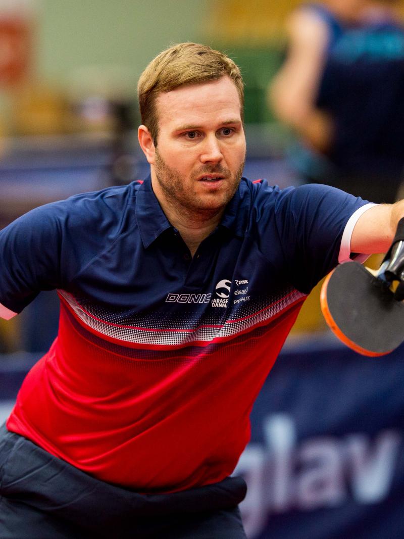 male Para table tennis player Peter Rosenmeier plays a forehand
