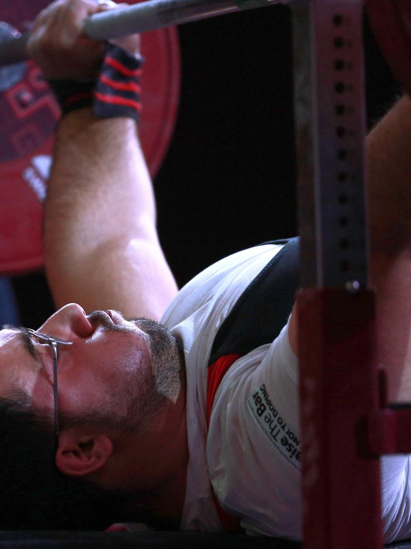 male powerlifter Roohallah Rostami gets ready to lift the bar