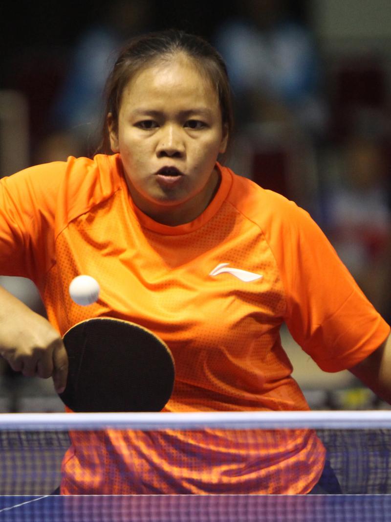 Woman in orange shirt playing table tennis