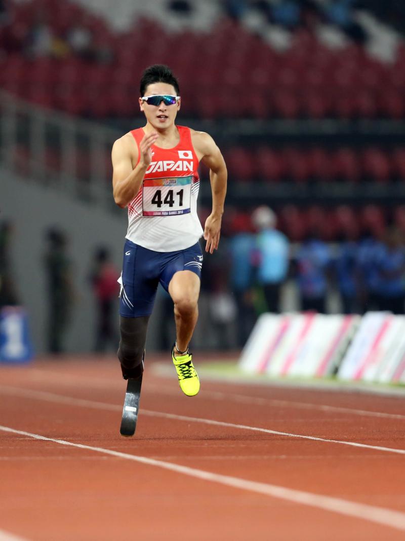 three male sprinters with Shunsuke Itani in the centre run down the 100m track