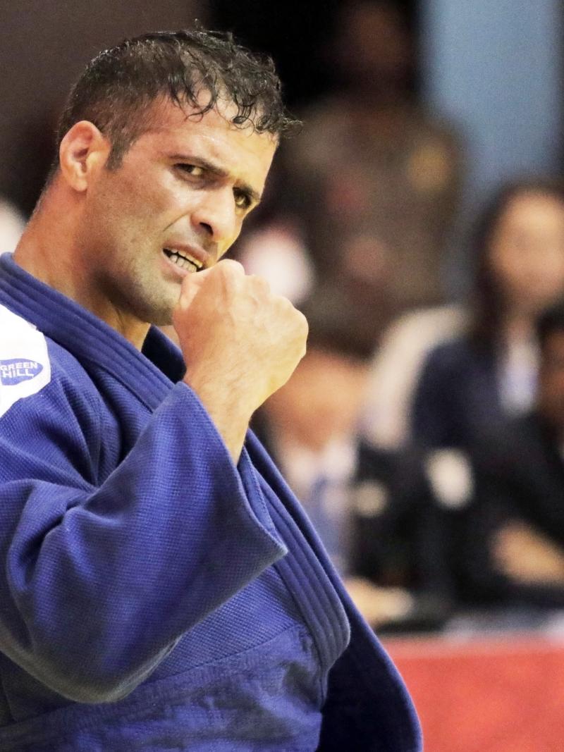 male judoka Ehsan Mousanezhad Karmozdi clenches his fist in victory