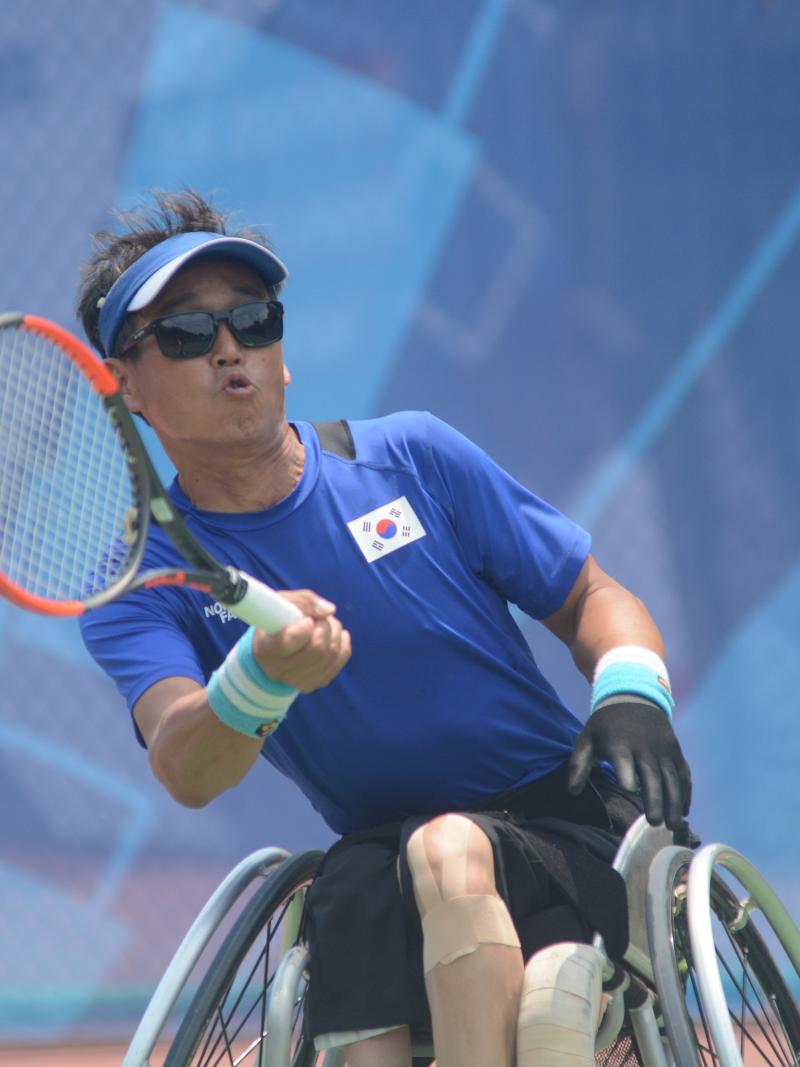 male wheelchair tennis player Kyu-Seung Kim plays a forehand