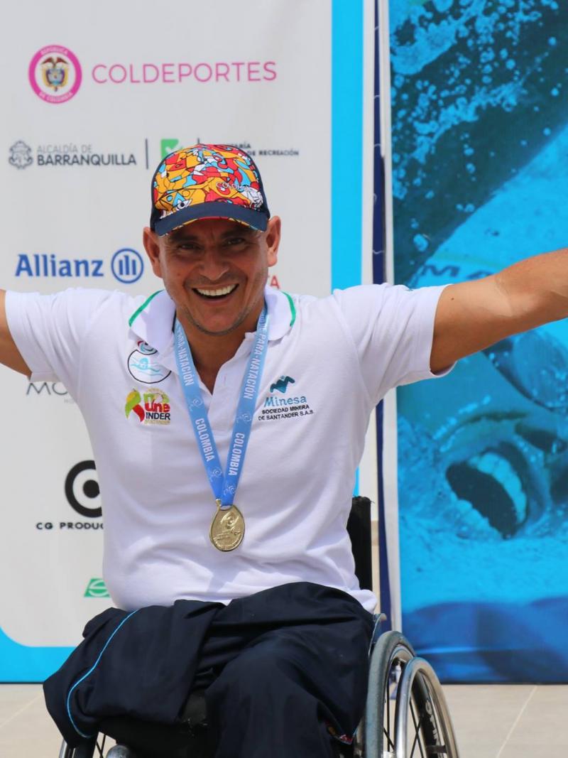 Colombian swimmer Moisés Fuentes smiling on the podium