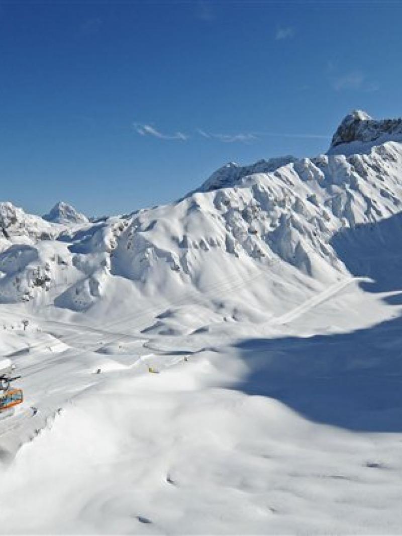 a wide shot of snowy mountains and a chairlift in Sella Nevea