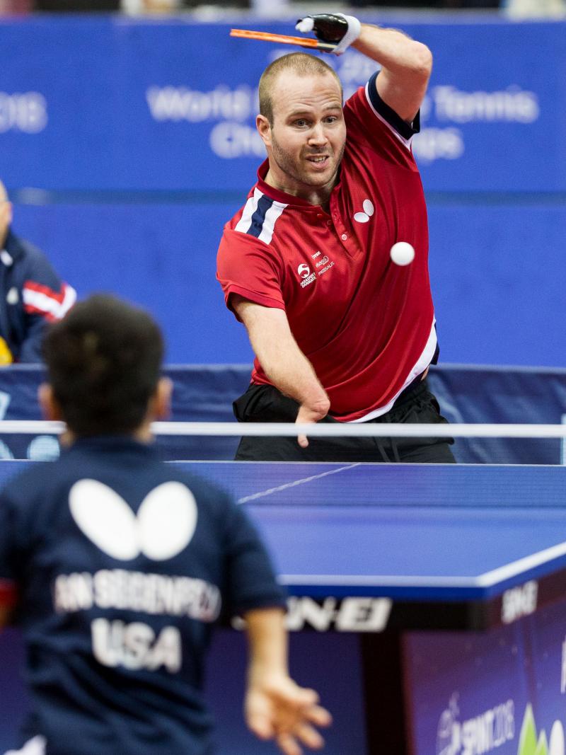 male Para table tennis player Peter Rosenmeier plays a forehand