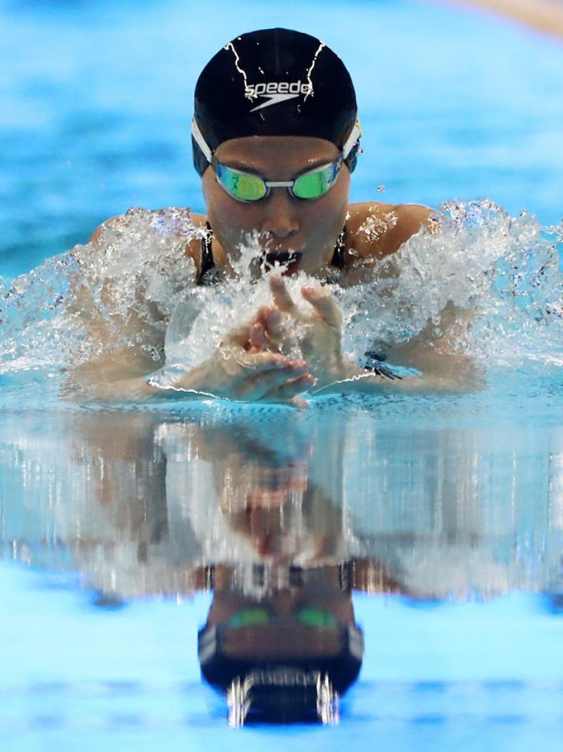 female Para swimmer Amilova Fatimakhon takes a breath during a breaststroke 