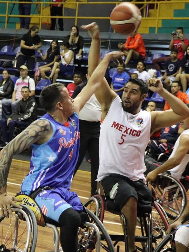 male wheelchair basketballers from Mexico and Puerto Rico fight for the ball