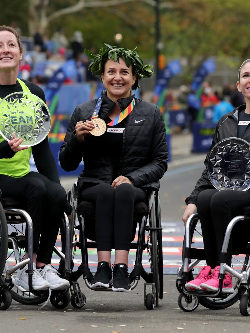 female wheelchair racers Tatyana McFadden, Manuela Schaer and Amanda McGrory holding up trophies