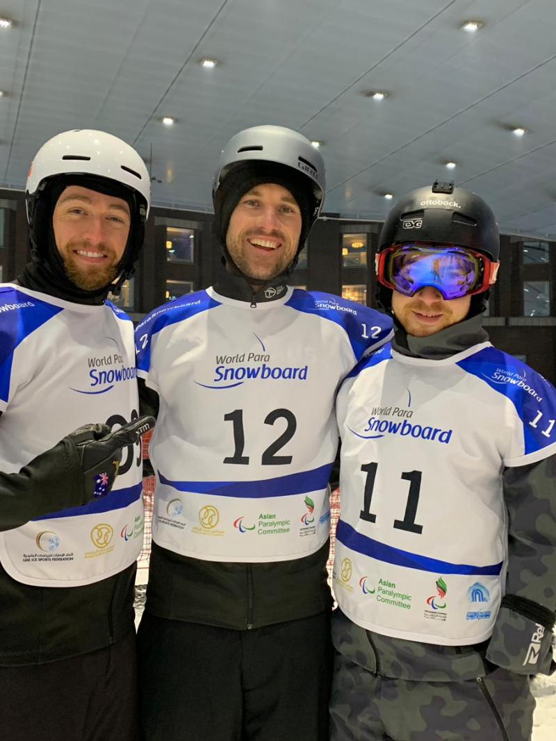 Three men with helmets in an indoor ski resort