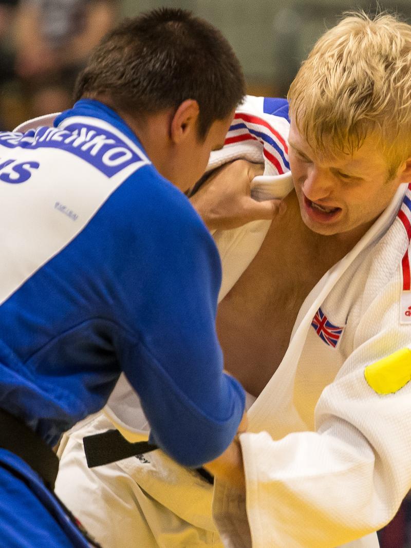 male judoka Chris Skelley wrestles with another fighter 