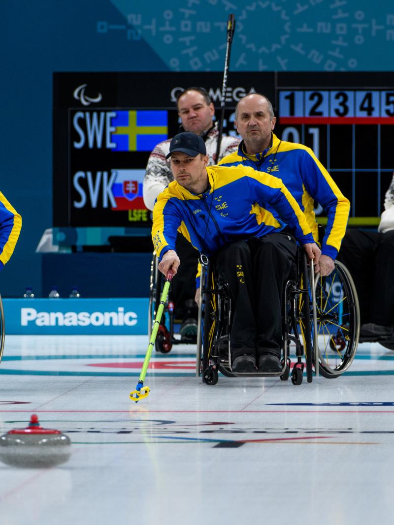 male wheelchair curler Viljo Petersson Dahl plays a stone on the ice