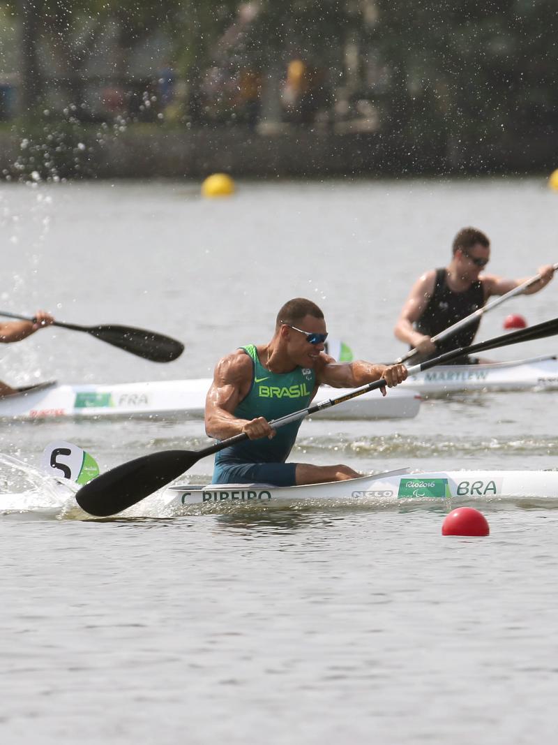 male Para canoeist Caio Carvalho mid-stroke during a race on the water