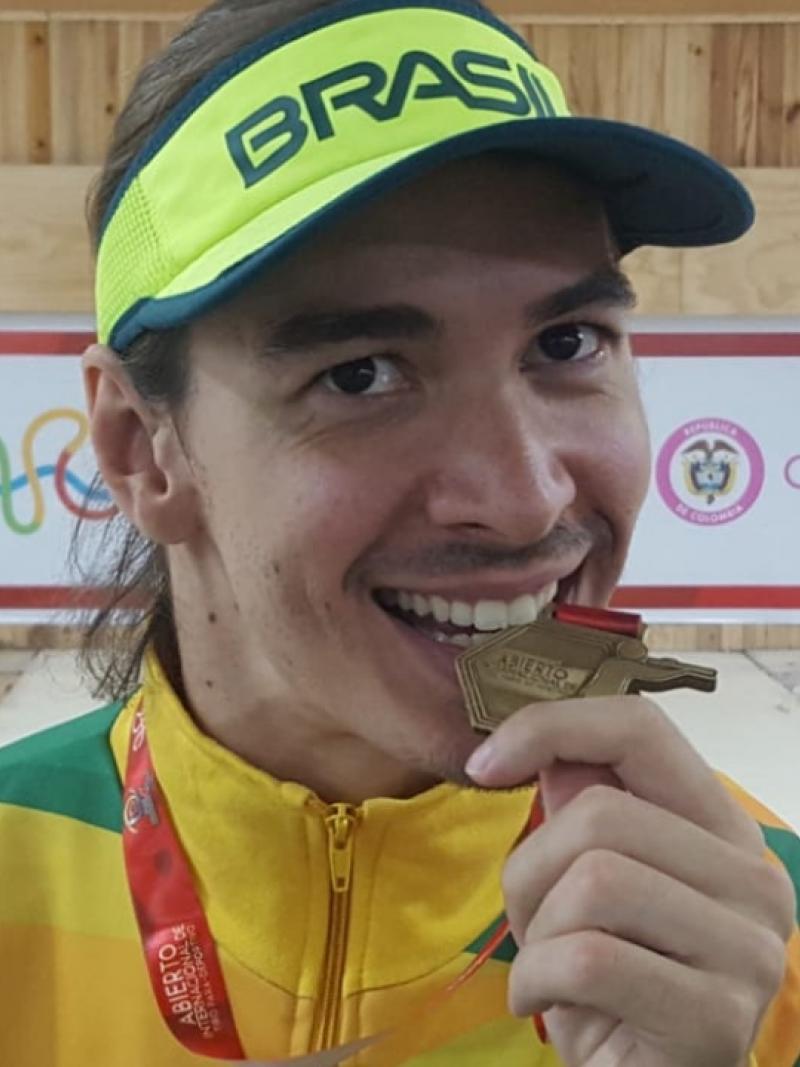 Brazilian male shooting Para sport athlete bites his gold medal