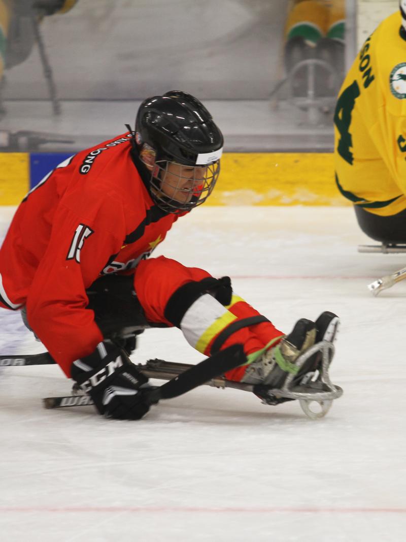 A man in a sledge playing Para ice hockey
