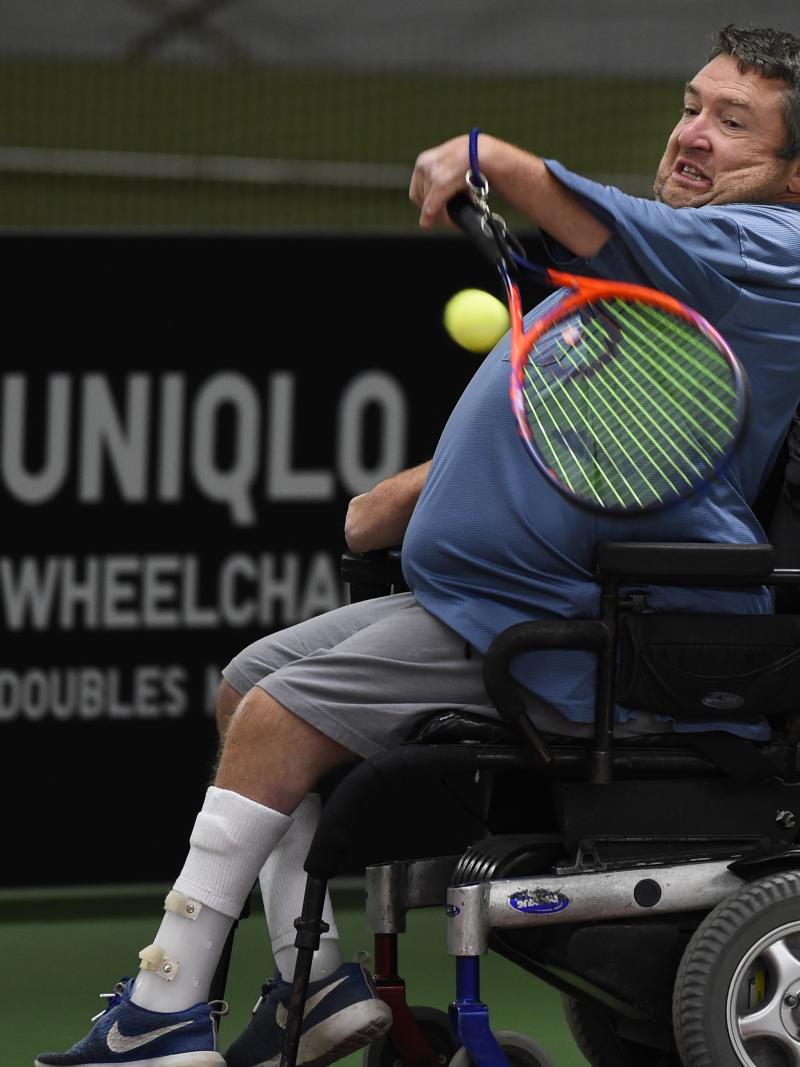 male wheelchair tennis player Nick Taylor plays a forehand on a hard court