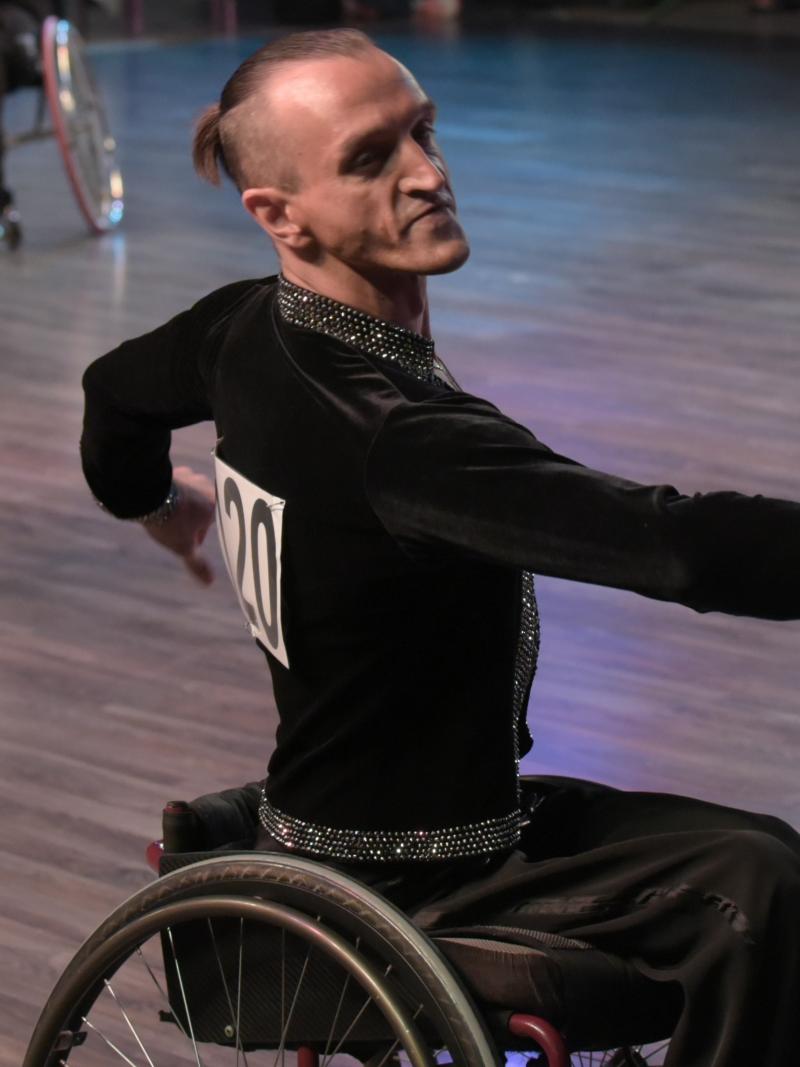 male Para dancer Ivan Sivak raises his arms in a wheelchair