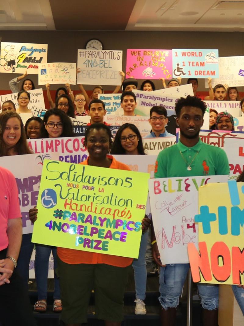 a group of students in a classroom holding up different coloured banners