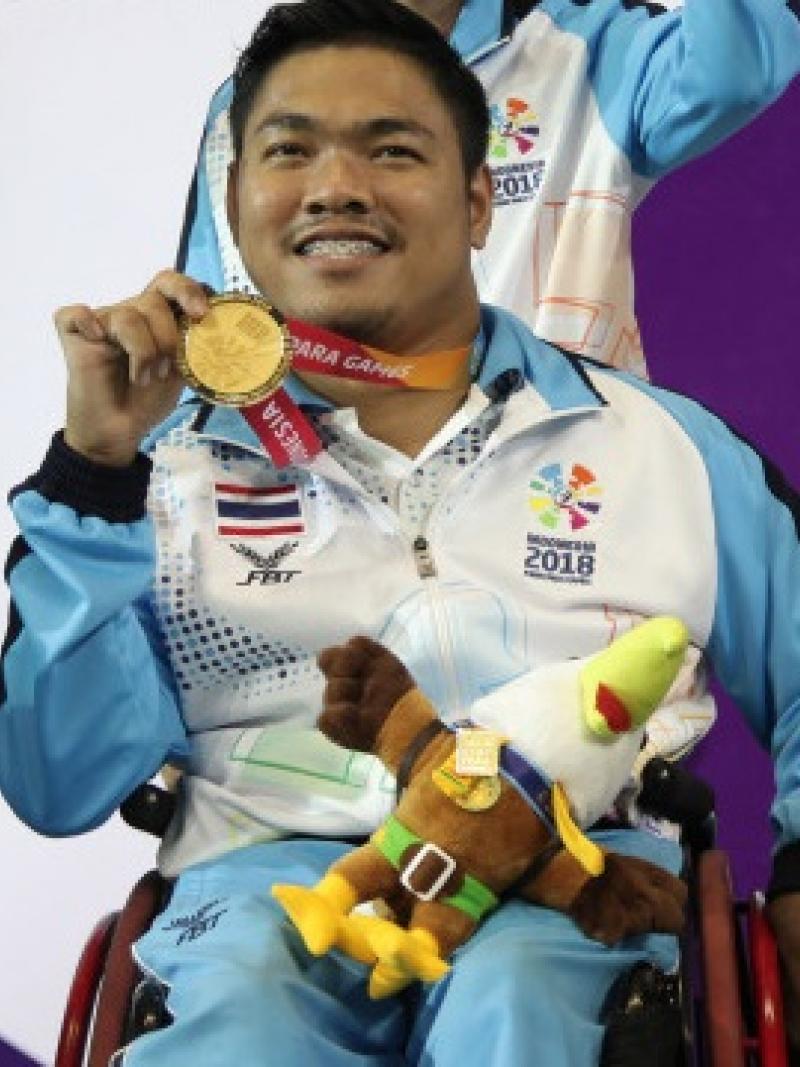 male boccia player Worawut Saengampa smiles and holds up his gold medal