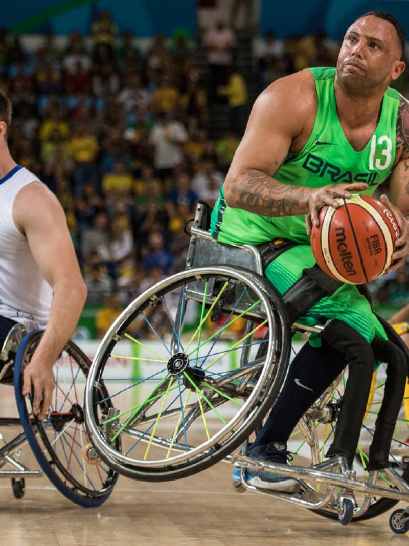 male wheelchair basketballer Leandro de Miranda shields the ball from another player
