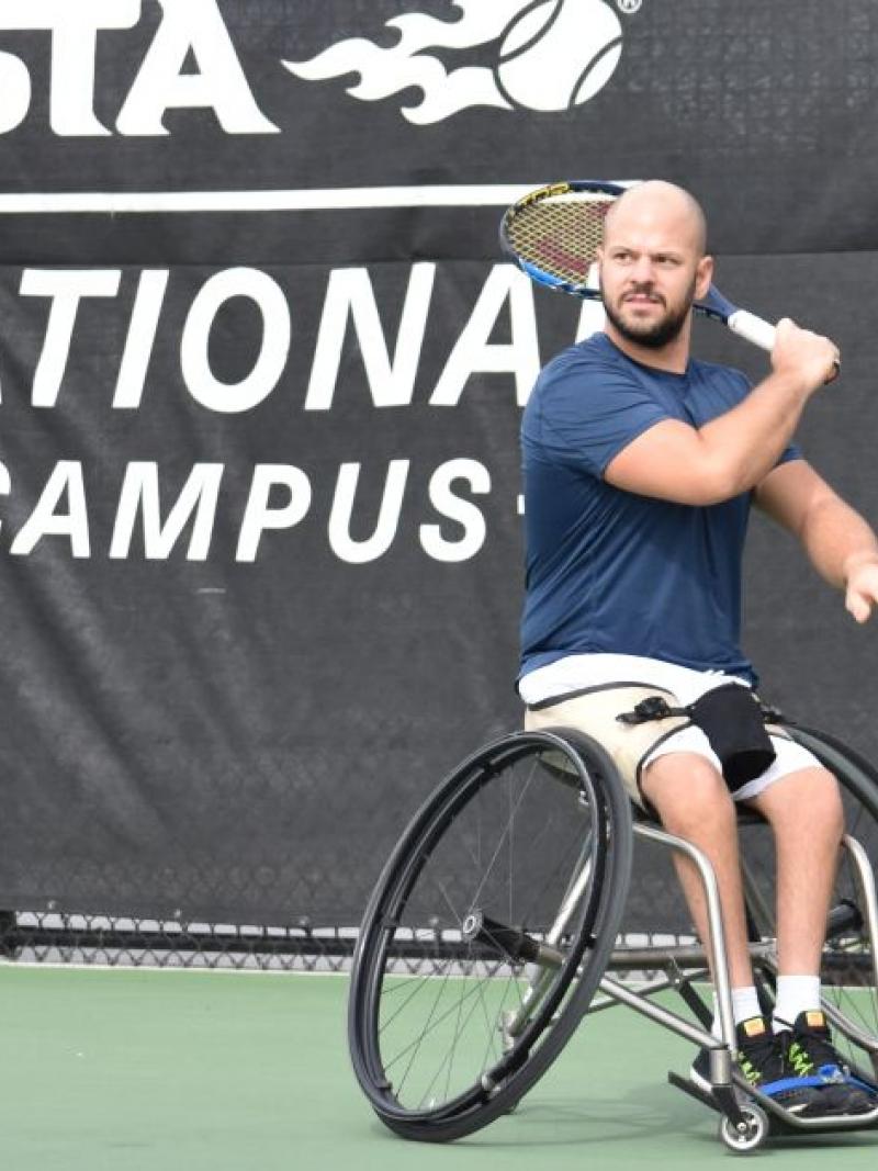 male wheelchair tennis player Stefan Olsson plays a forehand on a hard court