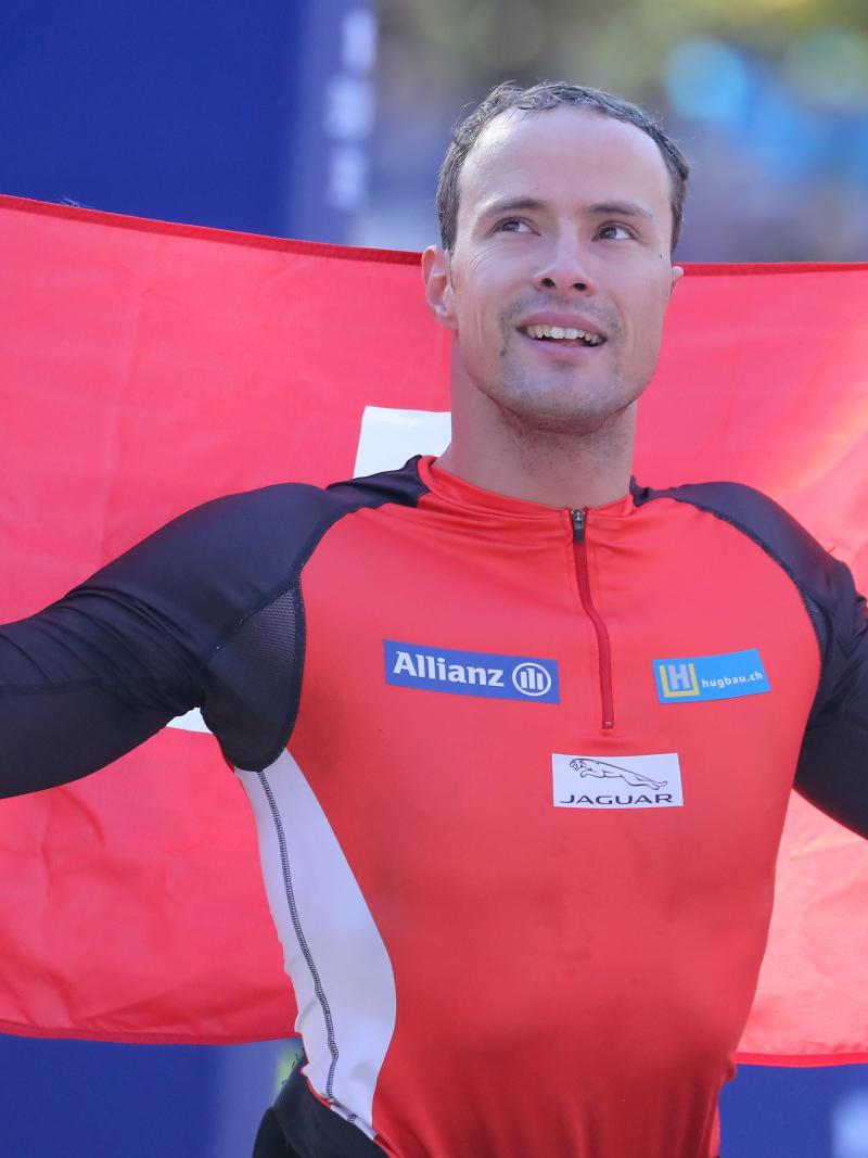 male wheelchair racer Marcel Hug holding up a Switzerland flag