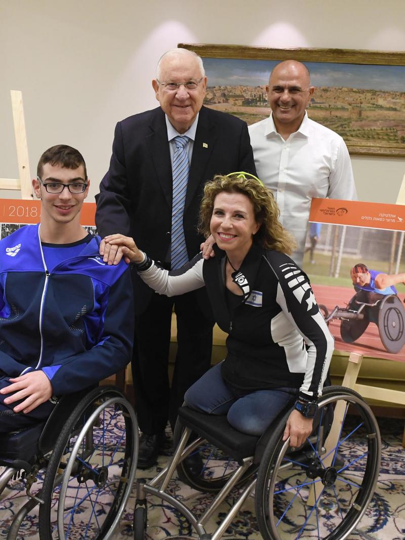 two people in wheelchairs seated next to two people standing