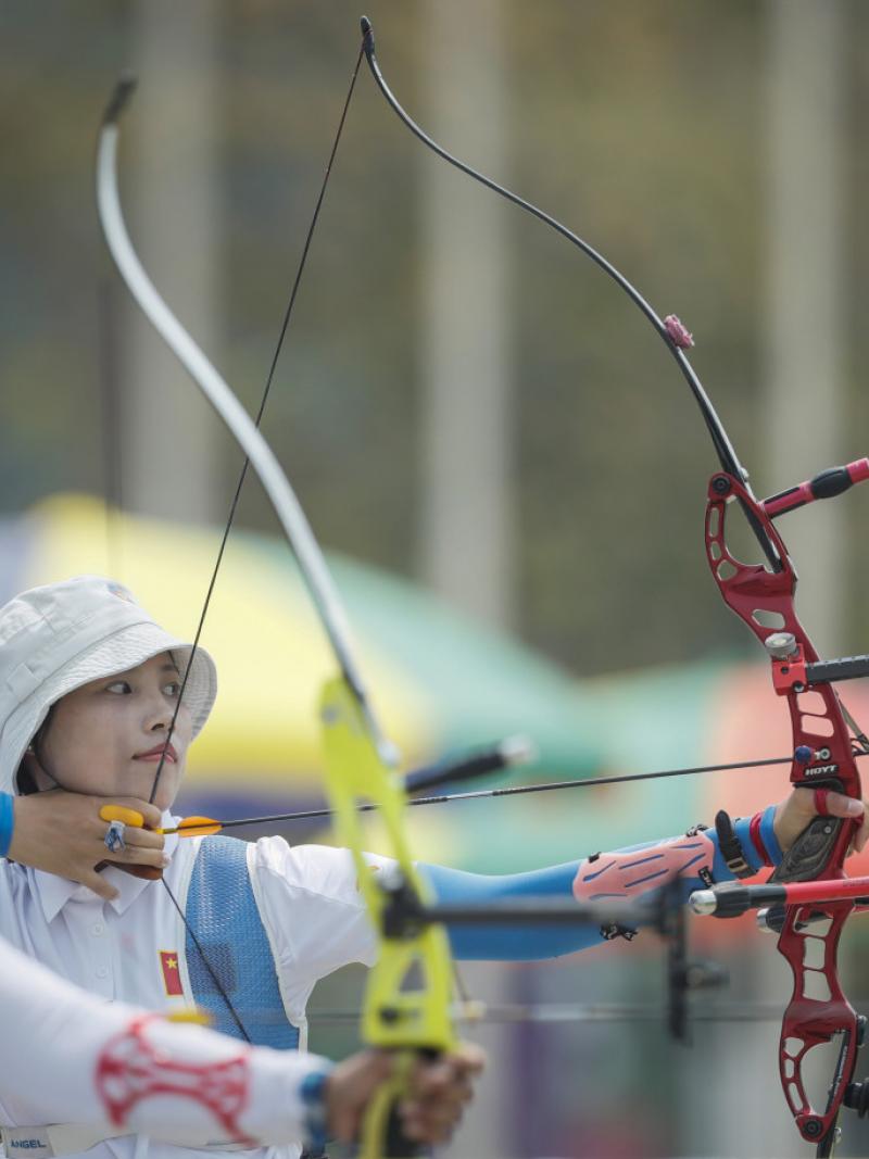 Chinese female archer pulls back her bow ready to shoot her arrow