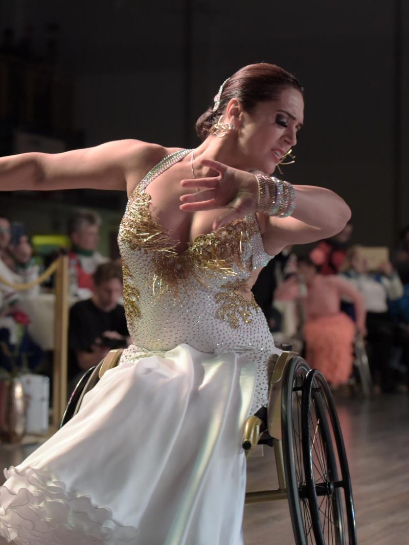 Ukrainian dancer in wheelchair wears glittering dress dances a conventional style